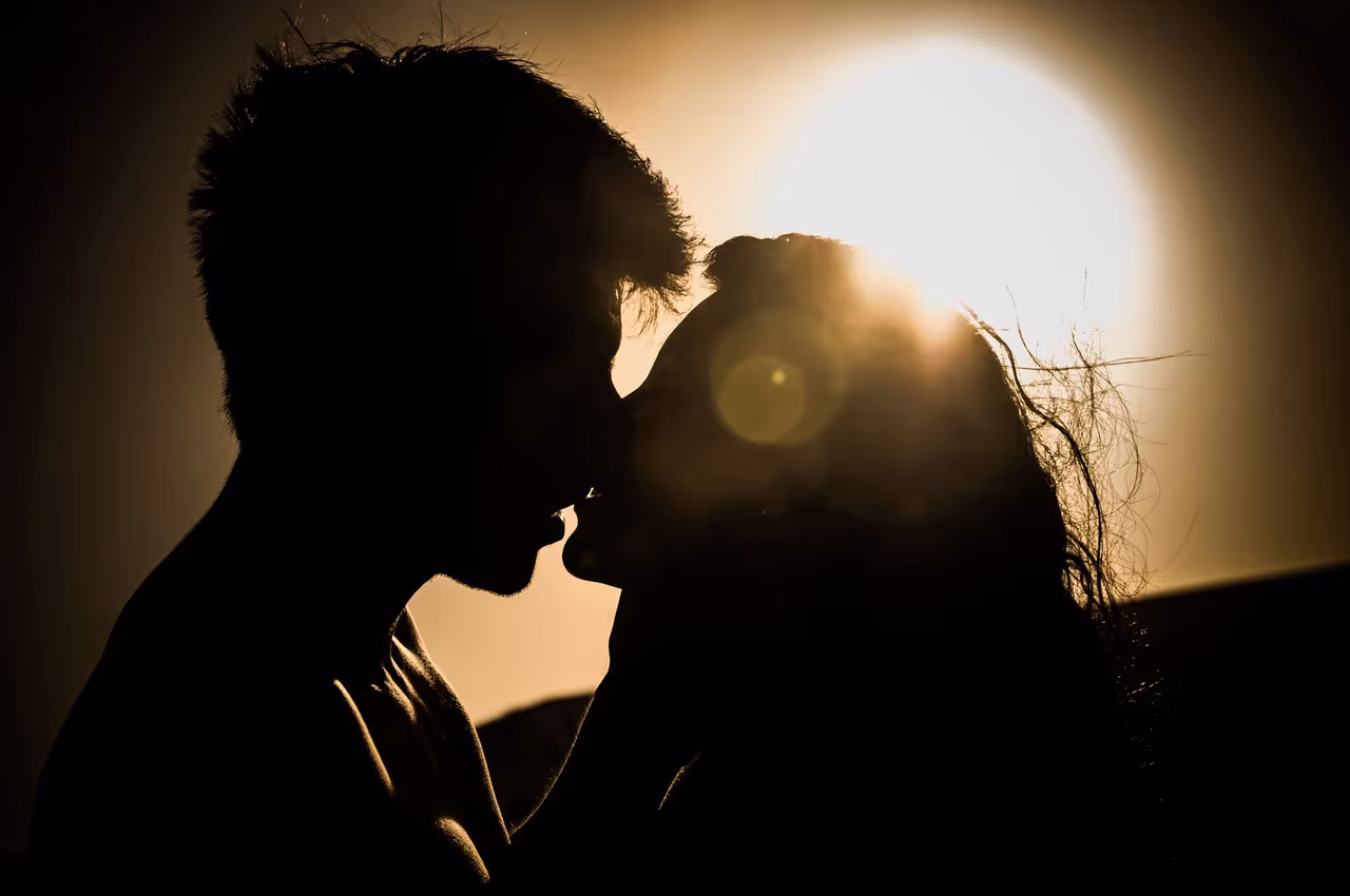 Silhouettes d'un couple s'embrassant lors du coucher de soleil